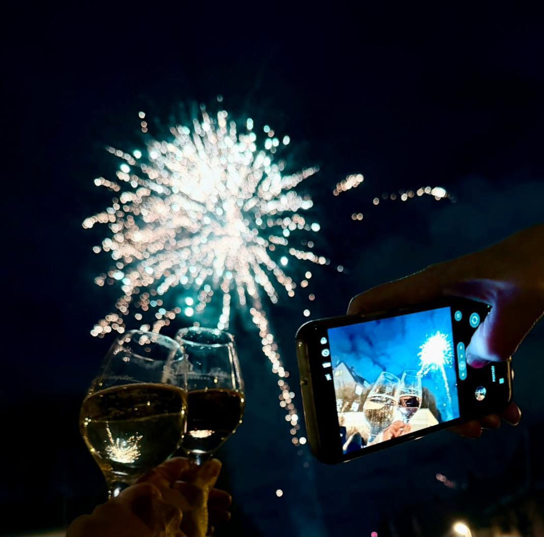 Glasses raised under fireworks outside the pub